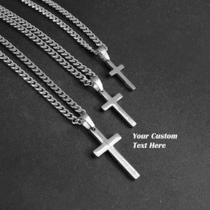 May include: Three silver chain necklaces with cross pendants. The cross pendants have engraved text, including "Our love you never ends".