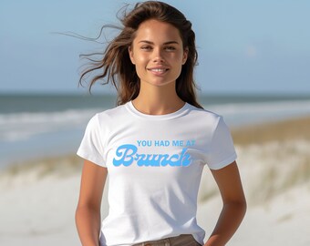 May include: White t-shirt with a blue graphic that says "You had me at Brunch".