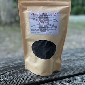 May include: A brown paper bag with a label that reads "Angry Viking Jerky" and "Maple". The bag contains jerky and has a net weight of 16oz (453g).