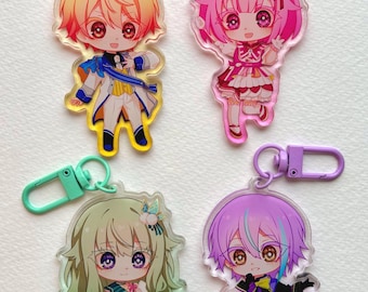 Puede incluir: Cuatro llaveros de personajes de estilo anime. Cada llavero presenta una colorida ilustración de un personaje con ojos grandes y atuendos detallados. Los llaveros tienen cierres de diferentes colores: amarillo, rosa, verde y morado.