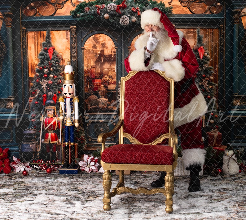 May include: Santa Claus in a red suit with white trim stands behind a red velvet chair with gold accents. He is holding his finger to his lips, as if to say 'shhh'.  A nutcracker stands in the background.