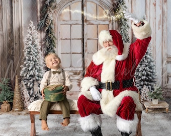 May include: Santa Claus, wearing a red suit with white trim and a white beard, sits on a wooden bench with a young boy. The boy is holding a green gift box. The scene is set in front of a white wooden door with a wreath and a snowy background.