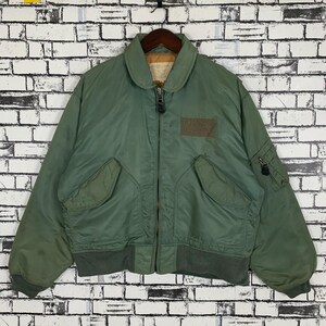 May include: A green bomber jacket with a zipper closure and multiple pockets. The jacket has a ribbed collar and cuffs.
