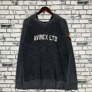 Puede incluir: Una sudadera con capucha negra de aspecto desgastado. La sudadera tiene un logotipo bordado en blanco que dice "AVIREX LTD" y un peque&ntilde;o parche en la manga izquierda.