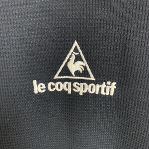 Puede incluir: Camiseta deportiva negra con un logotipo bordado blanco de un gallo en un tri&aacute;ngulo y el texto "le coq sportif".