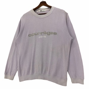 Puede incluir: Una sudadera de color lavanda con un logotipo bordado en gris que dice "Courr&egrave;ges Paris".