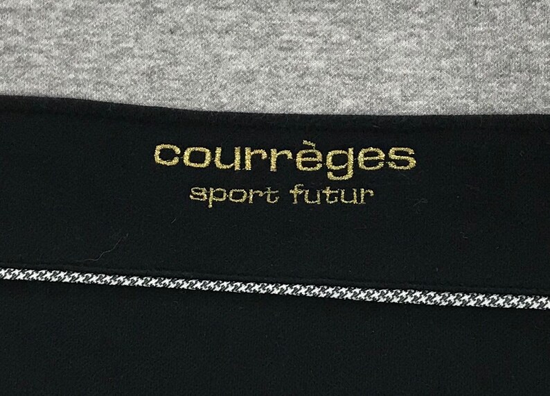 May include: A black and gold label with the text "Courr&egrave;ges sport futur" in gold lettering.