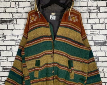 May include: A hooded cardigan with a striped pattern in shades of brown, green, and red. The cardigan has a button closure and two pockets. The label on the cardigan reads "Alpenstock".