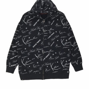 May include: Black zip-up hoodie with a white all-over print of the signature "Karl Kani" logo and the words "In My Truth".