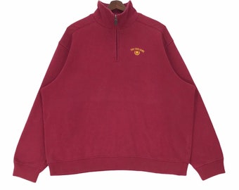 May include: A maroon half-zip sweatshirt with the text "USC Trojans" embroidered in yellow on the chest.