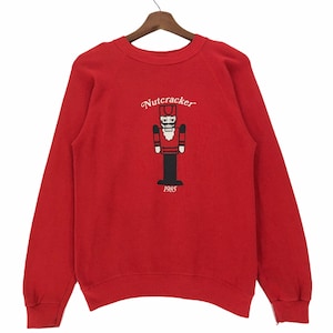 Puede incluir: Sudadera roja con un diseño de Cascanueces y el año 1985 impreso en la parte delantera.