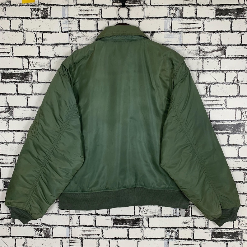 May include: A green bomber jacket with a zipper closure and a ribbed knit collar, cuffs, and waistband.