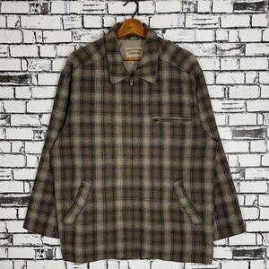 Puede incluir: Una chaqueta con cremallera de cuadros marrones y beige con una etiqueta que dice "Jacket & Company" y "Country Club".