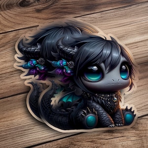 May include: A sticker featuring a cute, stylized black dragon with large teal eyes. The dragon has horns, a spiky collar, and teal accents on its wings and feet. The sticker is on a wooden surface.
