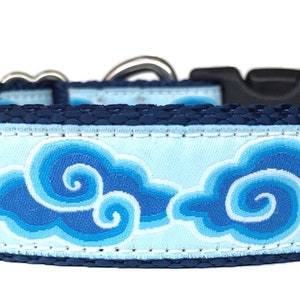 May include: A blue and white dog collar with a pattern of stylized clouds. The collar is made of durable nylon and has a sturdy buckle.