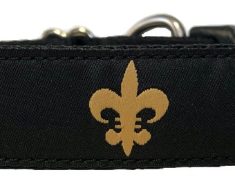 Könnte beinhalten: Schwarzes Hundehalsband mit goldenem Fleur-de-lis-Muster.