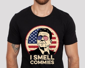 Camiseta unisex de manga corta con texto "I smell commies" (Huelo comunista) con texto "Reagan President" (Presidente Reagan)