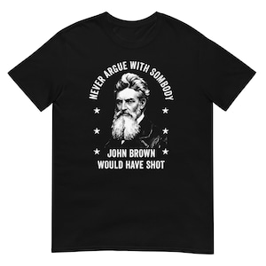 May include: Black t-shirt featuring a portrait of John Brown with a long white beard. The text reads "NEVER ARGUE WITH SOMBODY" above the portrait and "JOHN BROWN WOULD HAVE SHOT" below, with star accents.