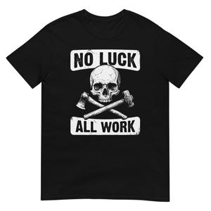 May include: Black t-shirt featuring a white skull with crossed axes and a hammer. The text "NO LUCK" is above the skull, and "ALL WORK" is below. The design has a distressed, vintage look.