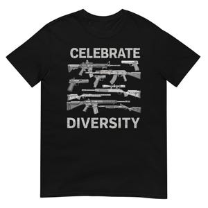 Peut inclure: T-shirt noir avec l'inscription blanche "CELEBRATE DIVERSITY", surmontant et soulignant une illustration d'armes à feu. Le design est imprimé dans un style vieilli.