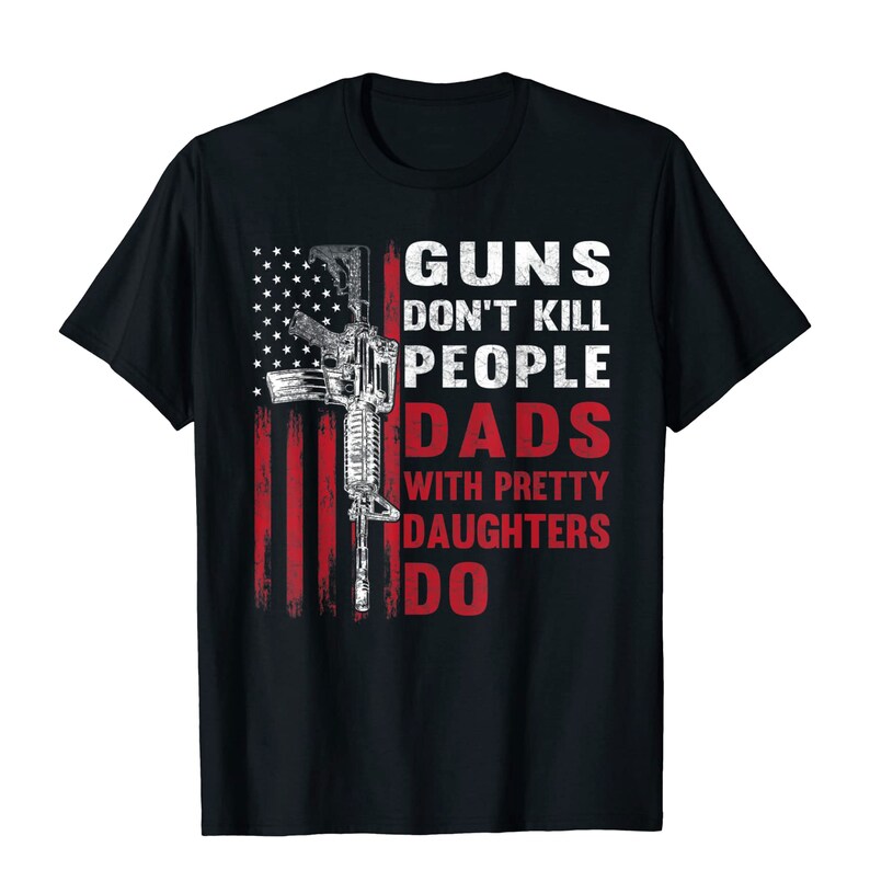 May include: Black t-shirt featuring a distressed American flag design with a rifle graphic. The text reads "GUNS DON'T KILL PEOPLE DADS WITH PRETTY DAUGHTERS DO" in white and red.