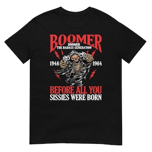May include: Black t-shirt with a graphic featuring a skull holding two pistols. The text reads "Boomer, The Badass Generation" above the skull, with the years 1946 and 1964 on either side. Below, it says "Before All You Sissies Were Born."