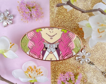 May include: An oval-shaped enamel pin featuring a smiling anime character with pink hair and green accents. The pin is set against a pink and gold glitter background, surrounded by white and pink flowers. The pin has a gold border.
