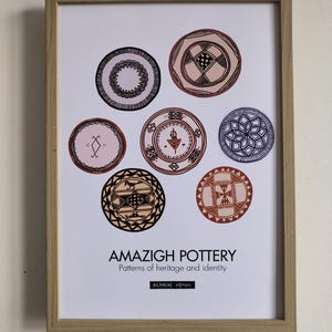 Puede incluir: Impresión enmarcada con siete diseños circulares de cerámica amazigh en varios colores y patrones. La impresión incluye el texto "AMAZIGH POTTERY Patterns of heritage and identity" y "BERBERS WOMAN".