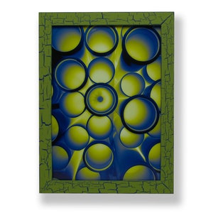 May include: A framed abstract art print with a green frame and a blue and yellow circular pattern.