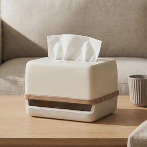May include: A rectangular off-white tissue box cover with a smooth finish, featuring a horizontal light wood accent band around the middle and a wide rectangular opening at the base, with a white tissue protruding from the top slot.