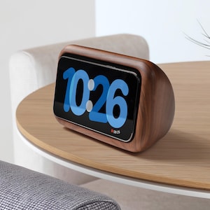 Peut inclure: Une horloge en bois avec un écran numérique affichant l'heure 10h26. L'horloge a une finition en bois brun foncé et une forme arrondie.