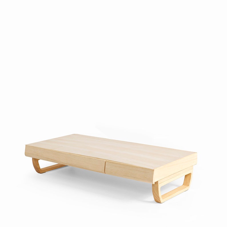 May include: A light wood coffee table with two drawers and curved legs. The table is made of natural wood and has a simple, modern design.