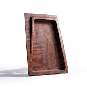 Peut inclure: Un plateau en bois brun foncé avec un bord surélevé et un petit plateau encastré. Le plateau est en bois de noyer et a une finition naturelle.