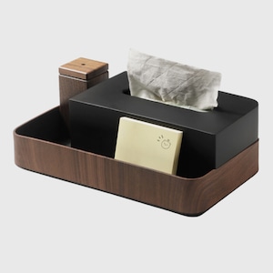 Op de afbeelding: Een houten tissueboxhouder met een zwarte tissueboxinzet. De houder heeft een compartiment voor een klein voorwerp, zoals een telefoon of een notitieblok. De tissuebox heeft een gleuf voor een tissuebox en een compartiment voor een notitieblok. De houder is gemaakt van hout en heeft een natuurlijke afwerking.