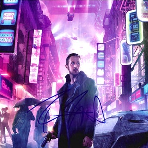 May include: A signed photograph featuring a man in a dark coat holding a gun, set against a futuristic cityscape with neon signs and rain. The scene is dominated by purple and pink hues, with a signature across the image.
