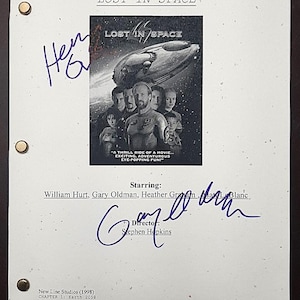Könnte beinhalten: Eine Film-Drehbuchseite für "Lost in Space" mit dem Filmtitel und den Darstellern. Die Seite ist von Gary Oldman signiert und enthält den Text: "A thrill ride of a movie... exciting, adventurous, eye-popping fun!"