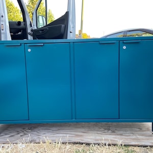 Puede incluir: Un mueble de color turquesa con cuatro puertas y patas cilíndricas cortas. El mueble tiene tiradores empotrados y cerraduras con ojo de cerradura. Las puertas son de color turquesa mate. El mueble mide aproximadamente 120 cm de ancho.