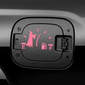 May include: Black fuel door with a pink graphic of a wizard casting a spell, replacing the fuel gauge. The gauge shows the fuel level with the letters "E" and "F" and a gas pump symbol.