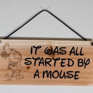 It was all started by a mouse. Steamboat Willie Inspired.  Hand painted and Laser engraved sign. Cedar fence board. Black Paint.  WW-DREF-N