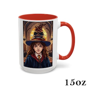 May include: A white ceramic mug with a red interior and handle. The mug features a colorful illustration of a person wearing a sorting hat. The mug is labeled "15oz".