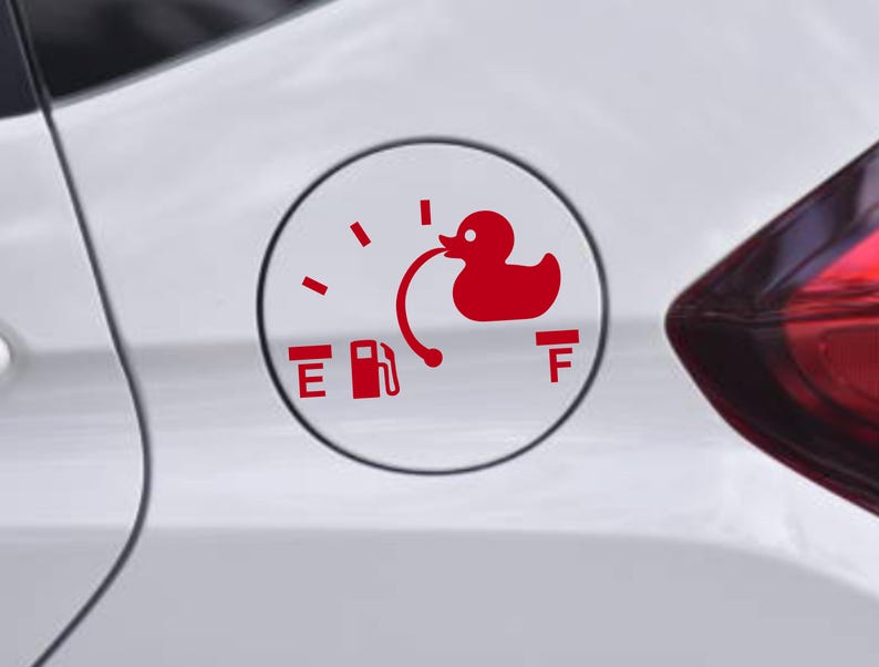 May include: A red vinyl decal applied to a white car fuel door, featuring a fuel gauge design. The graphic includes the letters E and F, a gas pump icon, and a rubber duck silhouette connected to the gauge needle by a curved line.