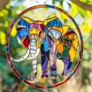 Peut inclure: Un capteur de soleil en vitrail représentant un éléphant avec un motif géométrique coloré. L'éléphant est encadré par une bordure circulaire. L'éléphant présente une variété de couleurs, dont le bleu, le jaune, le rouge et le violet. Le capteur de soleil est conçu pour être suspendu.