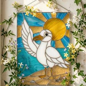 Puede incluir: Vidriera de una gaviota con el ala extendida, sobre un fondo de sol y mar azul y dorado. La obra está enmarcada y cuelga de una cadena. Enredaderas verdes y flores rodean la obra.