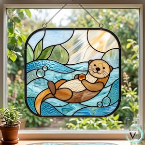 Pode incluir: Painel de vitral com uma lontra brincalhona flutuando em água azul, segurando um pequeno objeto. O fundo inclui um sol, céu e folhagem verde. O painel é emoldurado em preto e pendurado por uma corrente.