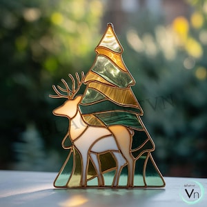 May include: Stained glass Christmas tree and deer figurine. The tree is composed of green and gold glass panels, and the deer is white and tan. The figurine has a gold metal outline and is designed to stand upright. A festive holiday decoration.