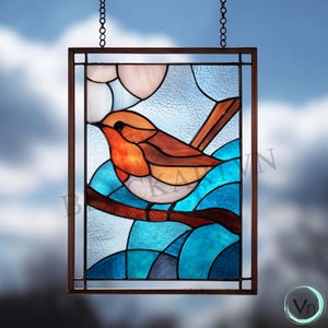 May include: Stained glass panel featuring a bird with orange and brown feathers perched on a brown branch. The background has blue and white abstract shapes, and the panel is framed in a dark brown border. The panel is suspended by a chain.