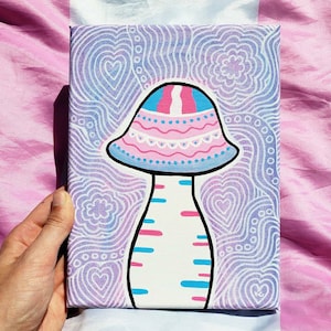 May include: A canvas painting featuring a whimsical mushroom design. The mushroom cap is adorned with pink and blue stripes and decorative patterns. The background is a gradient of purple and white, with heart and swirl motifs. The artwork is held by a hand.