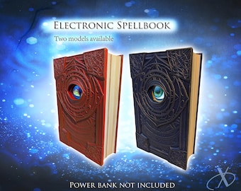May include: Two electronic spellbook covers, one red and one black, featuring intricate embossed patterns and a central eye design. The text reads: ELECTRONIC SPELLBOOK, Two models available, POWER BANK NOT INCLUDED. The books have light-colored pages.