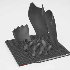 May include: A collection of dark gray 3D printed components arranged on a black grid build plate. The set includes three large, curved, shield-like panels and several smaller, hollow, cylindrical and rounded pieces with open ends.