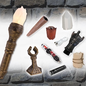 Op de afbeelding: Een verzameling fantasy-items, waaronder een fakkel met een gloeiende vlam, een houten pijp, een leren beker, een kristal, een USB-kabel, een zwart-zilveren apparaat, een hamer-vormig object, een rood-zwart apparaat, een zwarte cilinder met tekst en een klein bundeltje.